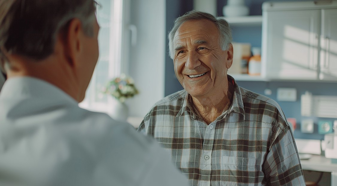 Médico urologista explicando para seu paciente, homem por volta dos 60 anos, sobre a inflamação na próstata e sintomas mais comuns. 