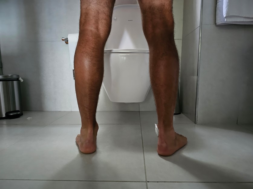 Imagem de um homem urinando sangue ao usar seu banheiro. 