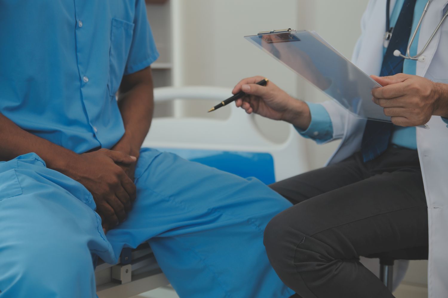 Homem com suspeita de próstata aumentada relatando sintomas ao médico em consulta.