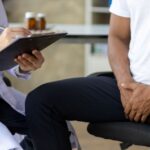 Homem em consulta com médico para saber se próstata aumentada causa impotência.