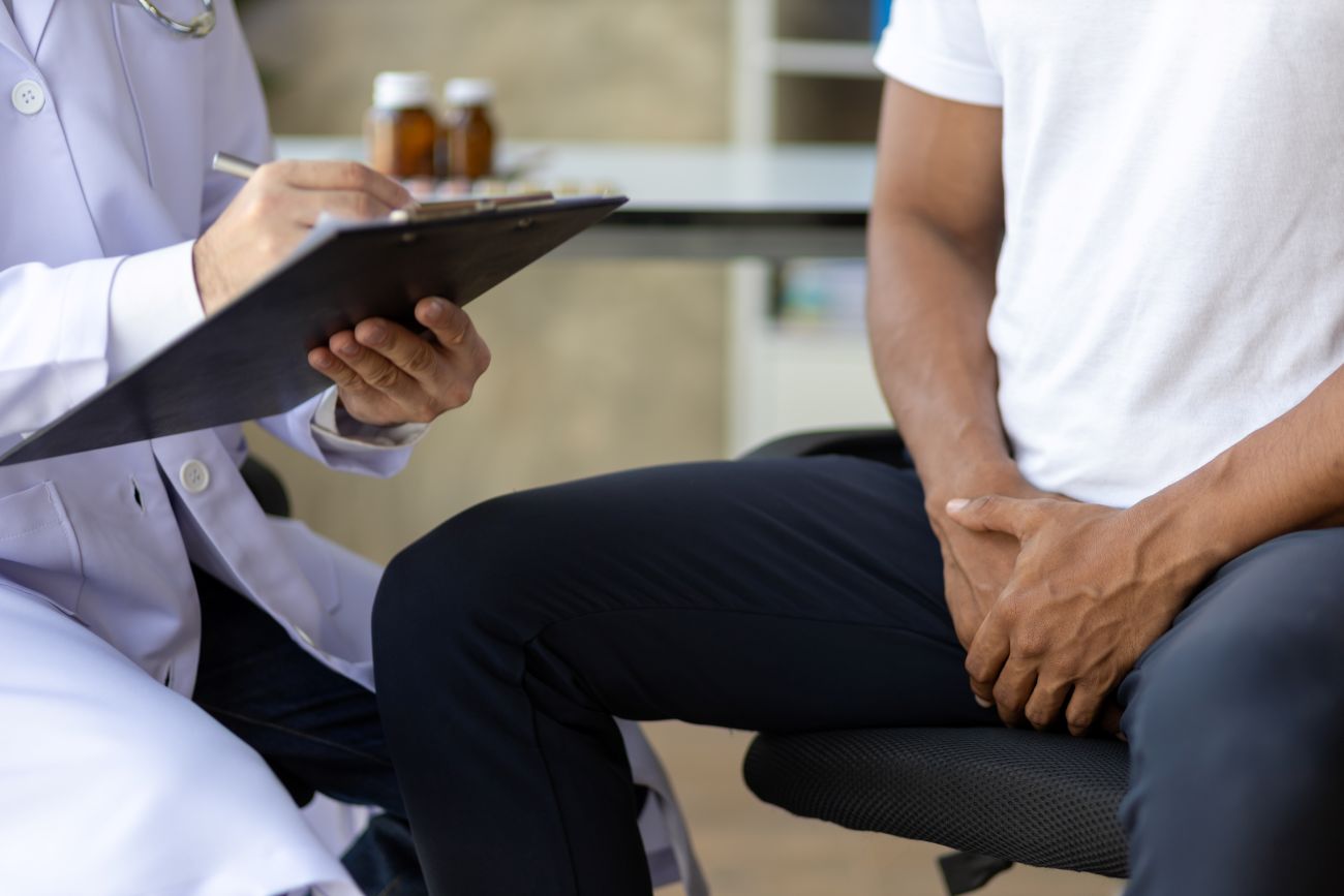 Homem em consulta com médico para saber se próstata aumentada causa impotência.