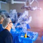 Centro cirúrgico moderno com cirurgia robótica em andamento, representando tecnologia e desafios do procedimento.