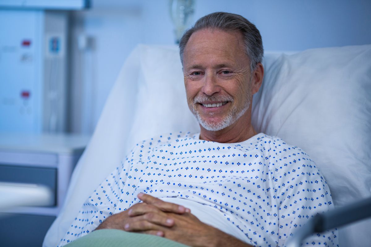 Homem em recuperação após raspagem da próstata, internado em ambiente hospitalar, ilustrando o pós-operatório do procedimento RTU.