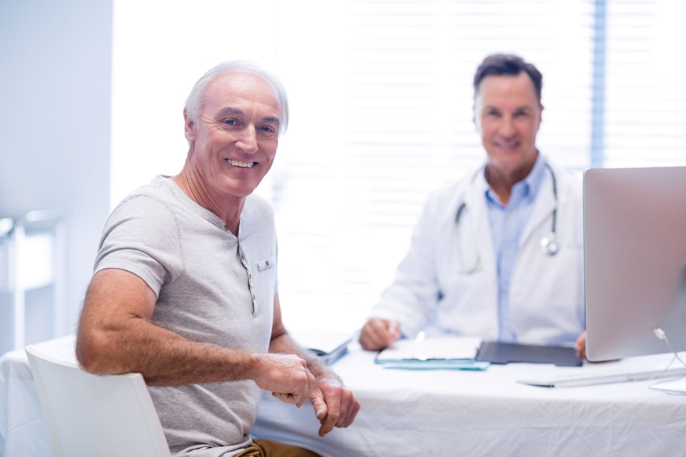 Paciente em consulta com urologista, discutindo vida sexual e retorno às relações após tratamento de câncer de próstata.